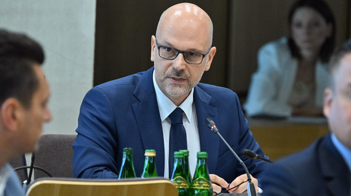 Maciej Berek może ominąć Pałac Prezydencki. Jego wejście do Trybunału Konstytucyjnego może zmienić układ sił W polskiej polityce i wymiarze sprawiedliwości ponownie pojawia się temat przyszłości Trybunału Konstytucyjnego oraz wpływu, jaki na jego funkcjonowanie mogą mieć decyzje podejmowane przez większość parlamentarną. Jednym z nazwisk, które w tym kontekście wzbudza zainteresowanie, jest Maciej Berek. Jego ewentualne wejście do Trybunału byłoby wydarzeniem o dużym znaczeniu politycznym i instytucjonalnym. Sprawa jest szczególnie interesująca ze względu na relacje pomiędzy rządem, parlamentem, prezydentem oraz samym Trybunałem Konstytucyjnym. W ostatnich latach kwestie związane z obsadą najważniejszych stanowisk państwowych stały się jednym z głównych elementów sporu politycznego w Polsce. Każda zmiana personalna w instytucjach konstytucyjnych może więc być analizowana nie tylko pod kątem formalnoprawnym, lecz także jako element szerszej walki o wpływy. Kim jest Maciej Berek? Maciej Berek jest prawnikiem i urzędnikiem państwowym od lat związanym z administracją publiczną. W swojej karierze zajmował się między innymi funkcjonowaniem Rady Ministrów, procesem legislacyjnym oraz organizacją pracy administracji rządowej. Dzięki doświadczeniu zdobytemu w strukturach państwa jest postacią dobrze znaną w kręgach administracyjnych. Jego nazwisko nabrało szczególnego znaczenia w okresie, gdy rozpoczęła się dyskusja dotycząca zmian w funkcjonowaniu instytucji państwowych oraz sposobu przywracania prawidłowego działania organów konstytucyjnych. Ewentualne powierzenie mu funkcji związanej z Trybunałem Konstytucyjnym byłoby zatem postrzegane jako decyzja o potencjalnie dużym znaczeniu. Nie chodziłoby wyłącznie o konkretną osobę, ale również o kierunek, w którym miałaby zmierzać jedna z najważniejszych instytucji stojących na straży zgodności prawa z Konstytucją. Dlaczego Trybunał Konstytucyjny jest tak ważny? Trybunał Konstytucyjny pełni w polskim systemie ustrojowym wyjątkową funkcję. Jego podstawowym zadaniem jest kontrolowanie zgodności ustaw i innych aktów normatywnych z Konstytucją. Orzeczenia Trybunału mogą więc mieć bezpośredni wpływ na funkcjonowanie państwa, obowiązywanie określonych przepisów oraz realizację polityki prowadzonej przez rząd i parlament. Z tego powodu skład Trybunału od lat jest przedmiotem zainteresowania polityków. Każda zmiana personalna może mieć znaczenie dla przyszłych rozstrzygnięć, choć nie oznacza automatycznie, że nowy sędzia będzie głosował zgodnie z oczekiwaniami określonego środowiska politycznego. Właśnie tutaj pojawia się kwestia tak zwanego „układu sił”. W debacie publicznej określenie to jest często używane do opisania różnic pomiędzy grupami mającymi odmienne poglądy na temat funkcjonowania Trybunału. Czy możliwe jest ominięcie Pałacu Prezydenckiego? Sformułowanie o „ominięciu Pałacu Prezydenckiego” odnosi się przede wszystkim do politycznego znaczenia procesu powoływania osób na najważniejsze stanowiska państwowe. W Polsce kompetencje prezydenta i parlamentu w tym zakresie wynikają z Konstytucji oraz ustaw. Dlatego każda próba zmiany personalnej w organie konstytucyjnym musi być analizowana przede wszystkim z perspektywy obowiązujących przepisów. Jednocześnie polityczny wymiar takich decyzji może być znacznie szerszy niż sama procedura prawna. Jeżeli określona kandydatura uzyska poparcie wymagane przez przepisy, a jej realizacja nie będzie wymagała dodatkowej decyzji prezydenta, wówczas Pałac Prezydencki może mieć ograniczony wpływ na sam proces. To właśnie taki scenariusz może być określany w debacie publicznej jako „ominięcie” prezydenta. Nie oznacza to jednak, że prezydent zostaje pozbawiony swoich konstytucyjnych kompetencji. Znaczenie ma dokładna podstawa prawna konkretnej nominacji oraz etap procedury, którego dotyczy dana decyzja. Możliwa zmiana w Trybunale Jeżeli Maciej Berek rzeczywiście znalazłby się w strukturach Trybunału Konstytucyjnego, mogłoby to wpłynąć na sposób postrzegania instytucji przez opinię publiczną. Dla części komentatorów byłby to sygnał dalszych zmian w funkcjonowaniu Trybunału. Dla innych byłby to element szerszego procesu porządkowania sytuacji prawnej po latach sporów. Najważniejsze pytanie dotyczyłoby jednak nie samego nazwiska, ale konsekwencji takiej zmiany. W przypadku organu kolegialnego znaczenie ma bowiem cały skład, a nie jedna osoba. Pojedyncza nominacja nie musi automatycznie prowadzić do całkowitego odwrócenia dotychczasowego układu. Może jednak stać się jednym z elementów większej zmiany, szczególnie jeżeli w podobnym czasie dochodziłoby do kolejnych zmian personalnych. Spór o niezależność Nie można również pominąć kwestii niezależności Trybunału. Od lat trwa w Polsce spór o to, w jakim stopniu jego działalność powinna być niezależna od bieżącej polityki. Zwolennicy reform wskazują na konieczność odbudowania zaufania do instytucji państwowych. Krytycy niektórych działań obawiają się natomiast, że zmiany personalne mogą zostać wykorzystane do zwiększenia wpływu polityków na sądownictwo konstytucyjne. W tym sporze każde nowe nazwisko jest więc oceniane przez pryzmat szerszej sytuacji politycznej. Maciej Berek, ze względu na swoje doświadczenie w administracji państwowej, może być szczególnie interesującą postacią w tej debacie. Jego dotychczasowa działalność sprawia, że ewentualna nominacja z pewnością byłaby dokładnie analizowana zarówno przez prawników, jak i politycznych komentatorów. Co może wydarzyć się dalej? Przyszłość tej sprawy będzie zależała przede wszystkim od formalnych decyzji oraz obowiązujących procedur. Samo pojawienie się nazwiska w przestrzeni publicznej nie oznacza jeszcze, że nominacja jest przesądzona. W przypadku Trybunału Konstytucyjnego szczególnie ważne będzie ustalenie, jaki dokładnie charakter miałaby ewentualna funkcja Berka, jaka procedura miałaby zastosowanie oraz jakie kompetencje przysługiwałyby poszczególnym organom państwa. Dopiero wtedy będzie można dokładnie ocenić, czy rzeczywiście doszłoby do istotnej zmiany układu sił. Jedno pozostaje jednak pewne: każda decyzja dotycząca składu Trybunału Konstytucyjnego będzie miała znaczenie wykraczające poza pojedynczą nominację. W obecnej sytuacji politycznej kwestia funkcjonowania sądownictwa konstytucyjnego pozostaje jednym z najważniejszych punktów sporu między obozami politycznymi. Ewentualne wejście Macieja Berka do Trybunału może więc stać się kolejnym etapem tej debaty. Czy rzeczywiście doprowadzi do zmiany układu sił? Na ostateczną odpowiedź trzeba będzie poczekać do momentu podjęcia konkretnych decyzji i poznania ich podstawy prawnej. Najważniejsze będzie przy tym nie samo polityczne znaczenie nazwiska, lecz to, czy planowane działania będą zgodne z Konstytucją, ustawami oraz zasadami niezależności instytucji państwowych. To właśnie te kwestie powinny znaleźć się w centrum publicznej dyskusji.